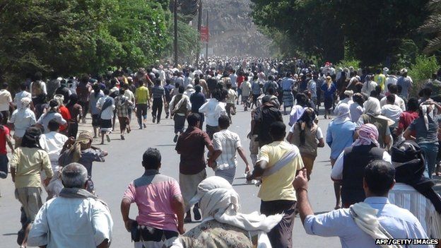 Residents of Aden run towards a weapons depot to take up arms in preparation for a potential advance on the southern Yemeni city by Huthi Shiite militia and their allies on 25 March 2015.