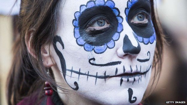 A protester with her face painted demonstrates outside Downing Street in London