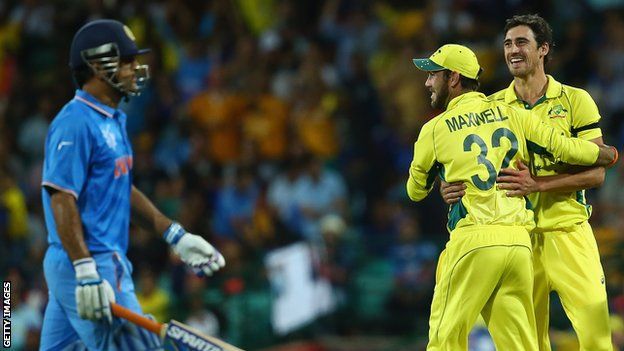 MS Dhoni of India looks dejected as Glenn Maxwell and Mitchell Starc of Australia celebrate his run out