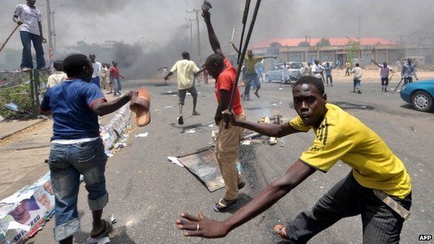 People holding wooden and metal sticks demonstrate in Nigeria's northern city of Kano where running battles broke out between protesters and soldiers on 18 April 2011 as President Goodluck Jonathan headed for an election win
