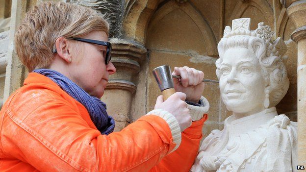 Sculptor Nina Bilbey puts the finishing touches to her statue of the Queen