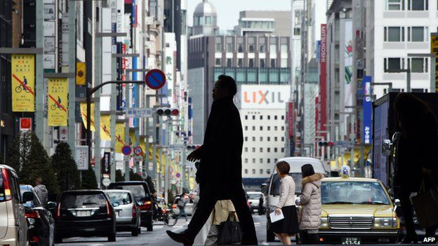 Pedestrians cross a street of the Ginza shopping district in Tokyo.