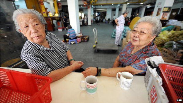 This photo taken on 14 April 2008 shows two elderly volunteers taking a break at the Singapore Buddhist Lodge where free vegetarian meals are served daily in Singapore.