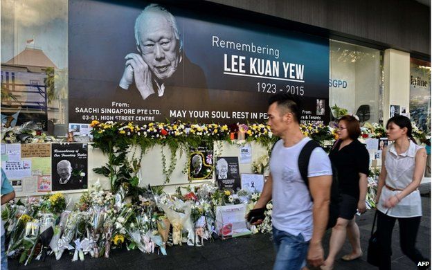 Pedestrians walk past a tribute corner for Singapore's late former prime minister Lee Kuan Yew who is lying in state at Parliament House in Singapore on 27 March 2015
