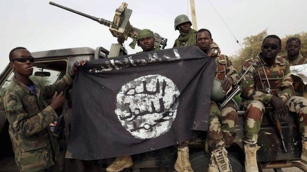 Soldiers from Niger with a Boko Haram flag after recapturing Damasak
