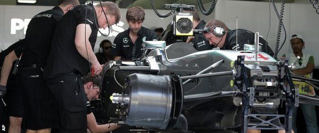 Mercedes mechanics fix British driver Lewis Hamilton's car at the team's garage after its engine failure during the first practice session