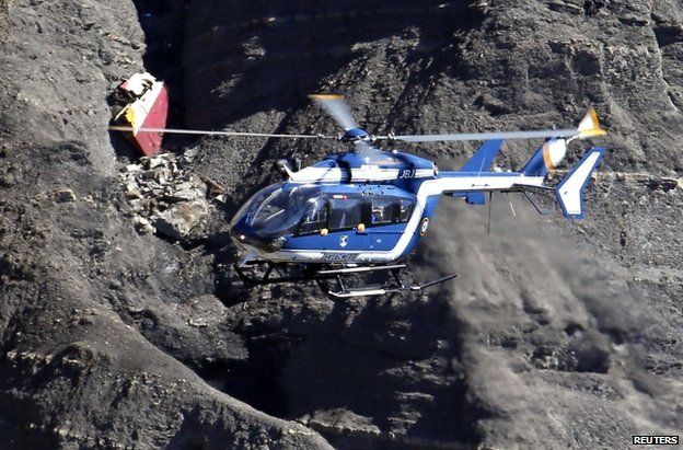 A French police helicopter flies over the crash site in the Alps, 27 March