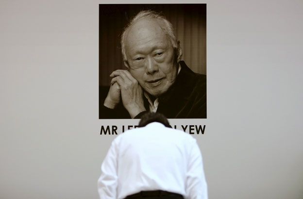 Man bowing before photograph of the late Lee Kuan Yew