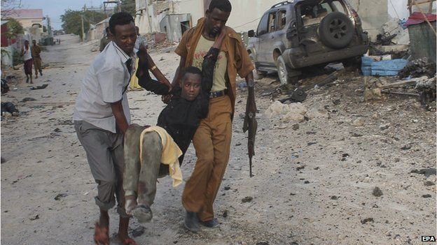 An injured man is evacuated from a scene of a car bomb explosion in front of a hotel in Mogadishu, Somalia, 27 March 2015