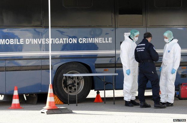 French police beside a Gendarmerie mobile forensic van in Seynes-les-Alpes, 27 March