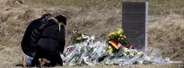 Relatives lay flowers in front of the monument in homage to the victims of Germanwings Flight 4U 9525 in Le Vernet, southeastern France, 27 March 2015.