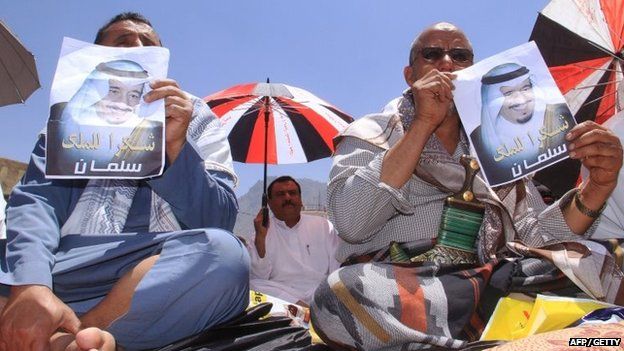 Yemenis hold placards bearing portraits of Saudi King Salman bin Abdulaziz al-Saud during a demonstration in the strategic city of Taez on 27 March 2015