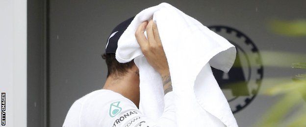 Lewis Hamilton dries his head after a wet qualifying session
