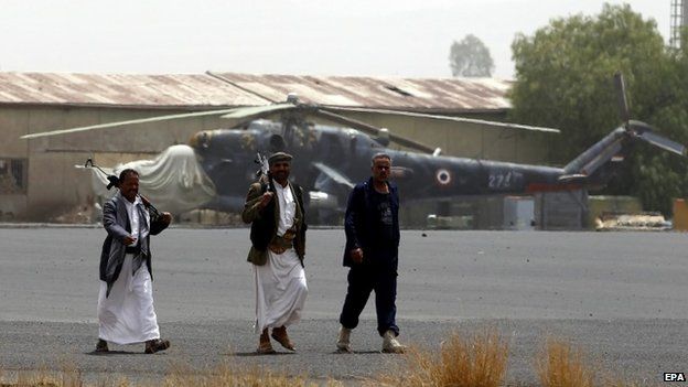 Armed members of Houthi militias walk on the tarmac of the military airport following an alleged airstrike by the Saudi-led coalition in Sana’a, Yemen, 28 March 2015