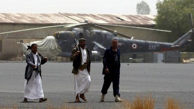 Armed members of Houthi militias walk on the tarmac of the military airport following an alleged airstrike by the Saudi-led coalition in Sana’a, Yemen, 28 March 2015