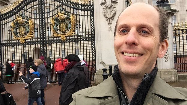 BBC reporter Anthony Zurcher stands outside Buckingham Palace.