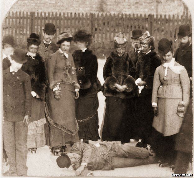 1876: People gather round a fallen rollerskater, who appears more amused than hurt