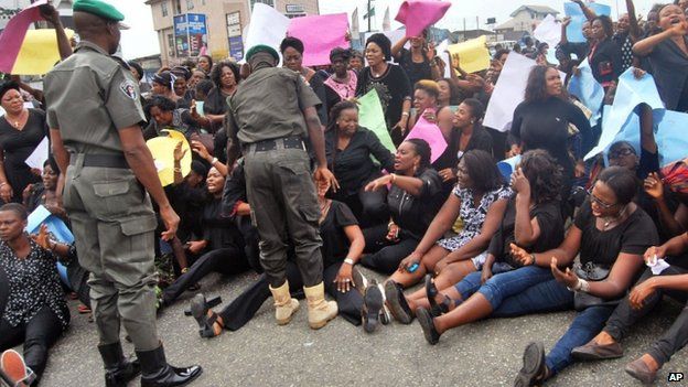 Nigerian troops, left, try to disperse woman members of the All Progressives Congress, APC, party as they protest against voting irregularities in the presidential election in Port Harcourt , Nigeria