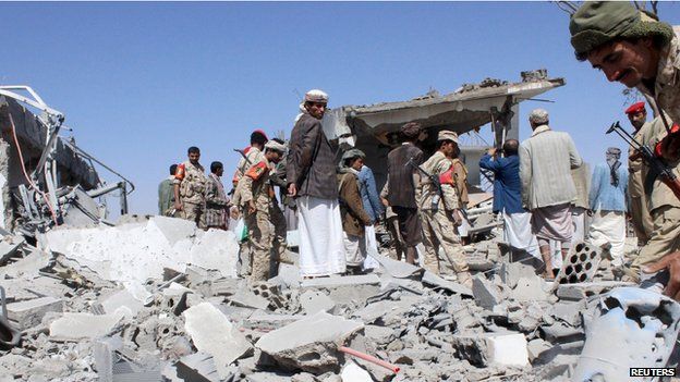 Soldiers and Houthi fighters inspect the damage caused by air strikes on the airport of Yemen's northwestern city of Saada on 30 March, 2015