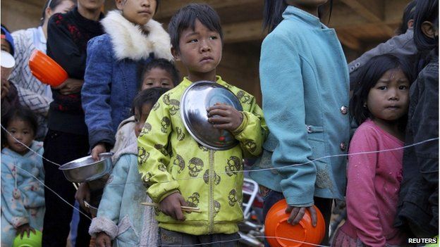 Children queue for food at a refugee camp at Myanmar's border town with China, in Kokang 21 February 2015