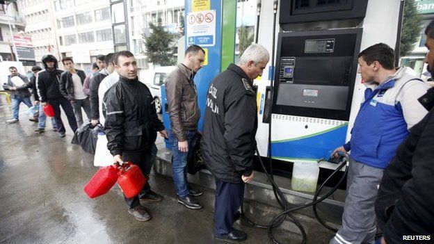 People line up for fuel at a petrol station in Istanbul