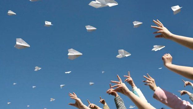 People throwing paper aeroplanes