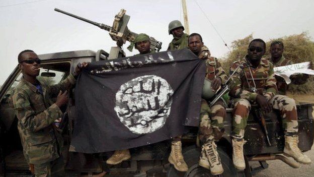 Nigerian soldiers displaying a Boko Haram black flag