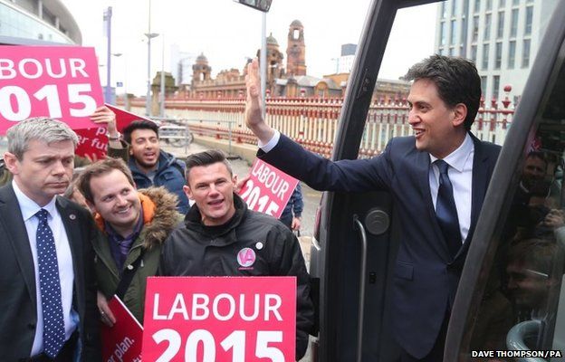 Labour Party leader Ed Miliband waves to supporters as he boards the party's battle bus after arriving at Manchester Piccadilly station