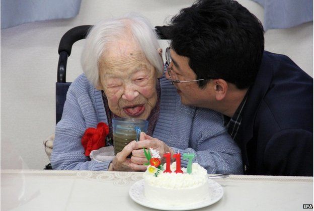 A handout picture provided by the Kurenai Nursing Home shows 117-year-old Japanese Misao Okawa (L) smiling before a birthday cake at the nursing home in Osaka, western Japan, 5 March 2015