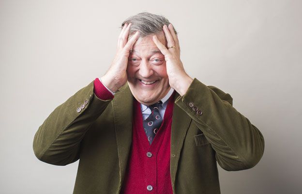 Stephen Fry with his head in his hands