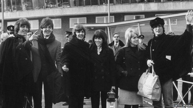 3th March 1965: British pop band The Beatles bidding farewell to their fans at London Airport as they leave to continue production of their film 'Help' in Austria. (Left to right) George Harrison (1943 - 2001), Paul McCartney, Ringo Starr (with Maureen) and John Lennon (1940 - 1980, with Cynthia)