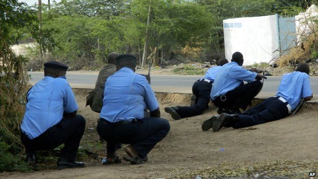 Kenyan police officers take cover outside the Garissa University College during an attack by gunmen in Garissa, Kenya, 2 April 2015