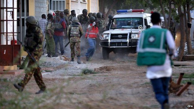 Kenyan soldiers and ambulance workers run as they prepare to evacuate students