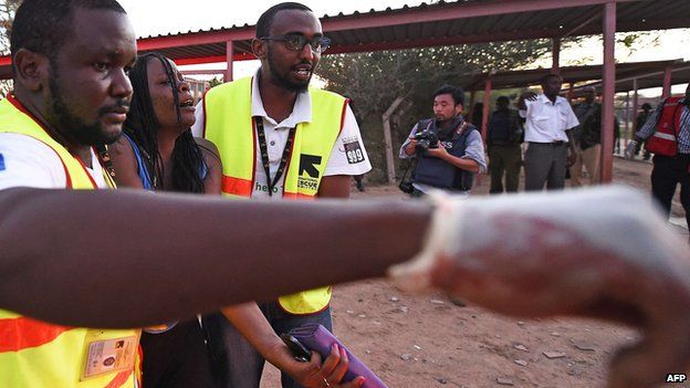 Paramedics lead away injured student at Garissa