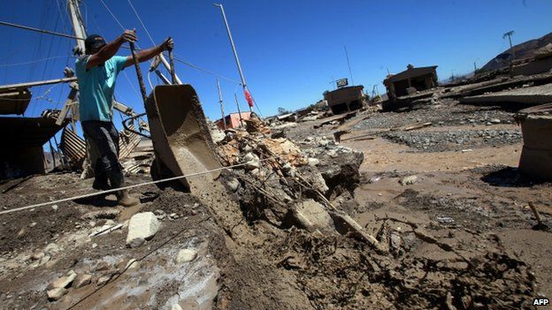 A man removes mud from his house after torrential rains and floods in Diego de Almagro, Chile, 28 March 2015.