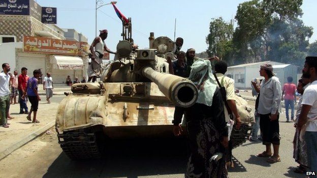 Tribal militiamen loyal to the Yemeni President gather beside a tank during clashes with Houthi fighters in the southern port city of Aden, Yemen, 2 April 2015.