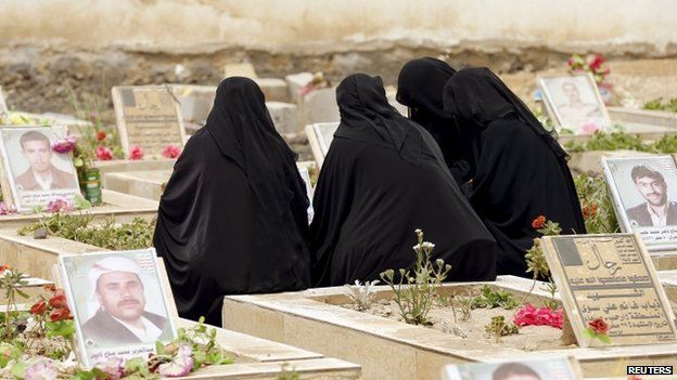 Women sit by the grave of a relative at a cemetery dedicated for Houthis killed in Yemen's ongoing conflict, in Sanaa 5 April 2015