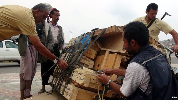 Tribal militiamen loyal to Yemeni President Hadi collect boxes full of weapons allegedly dropped by the Saudi-led coalition on 3 April 2015