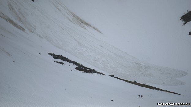 Men looking at avalanche debris