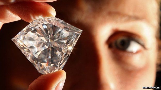 Man inspecting a large diamond