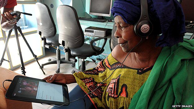 A woman uses a tablet at an internet cafe in Dakar, Senegal