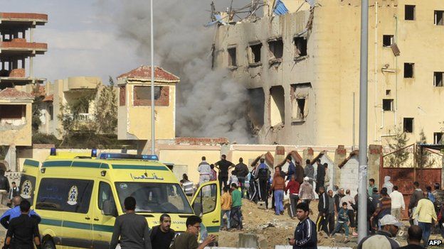 Egyptian residents and emergency personnel gather at the site of a car bomb in El-Arish on 12 April, 2015.