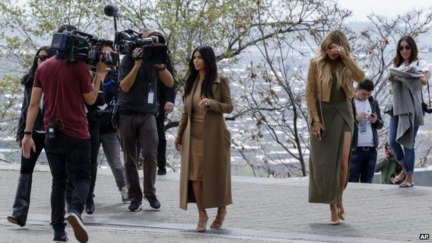 Kim Kardashian, centre, and Khloe Kardashian, right, walk in Victory Park while filming in Yerevan (9 April)
