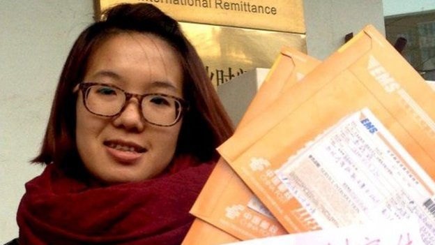 Women activist Wei Tingting, 26, poses for a photograph with letters and a paper which read "push ahead legal advocacy, request information disclosure, domestic violence should be punished by law!" in this undated file handout picture taken in an unknown location in China, provided by a women's rights group on 8 April 2015