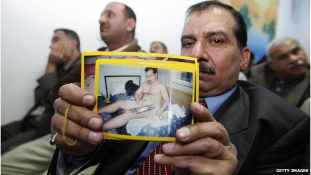 An Iraqi victim of a shooting incident holds up a picture of himself, during a meeting with US Federal Prosecutors to discuss the case against the security firm Blackwater
