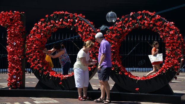 Visitors pay respects to Australia's Anzac soldiers as they pin a poppy to Wall of Remembrance in front of Queen Elizabeth cruise ship in Sydney on 3 March 2015