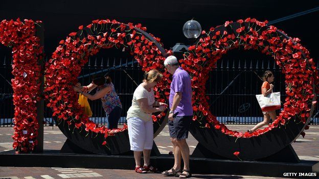 Посетители отдают дань уважения австралийским солдатам Анзака, которые прикрепляют мак к Стене памяти перед круизным лайнером королевы Елизаветы в Сиднее, 3 марта 2015 г.