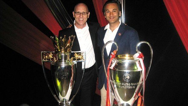 Joel Glazer (l) and Tehsin Nayani (r) with the Premier League and Champions League trophies
