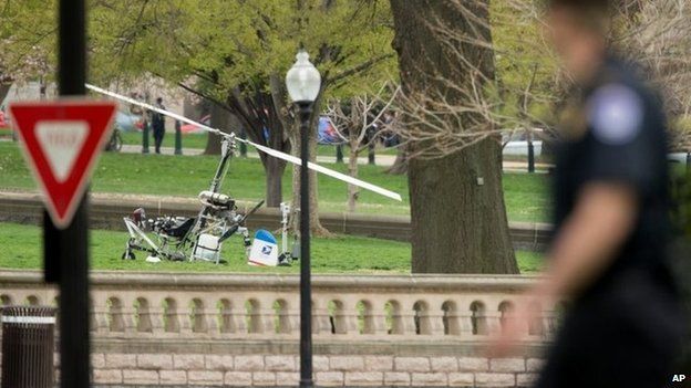 A Capitol Hill police officer looks toward a small helicopter that landed on the West Lawn of the Capitol in Washington 15 April 2015
