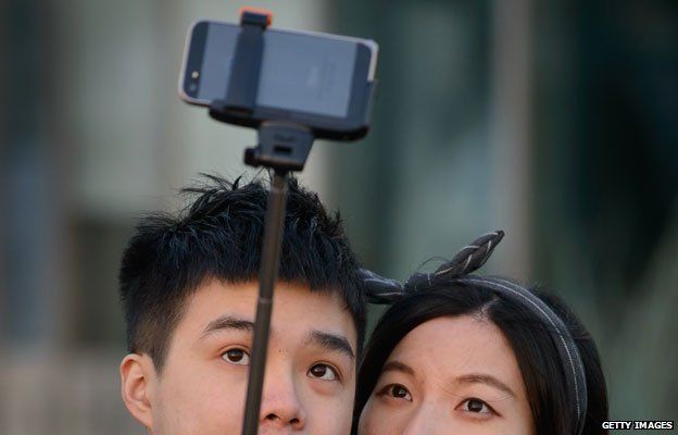 couple take photo with selfie stick